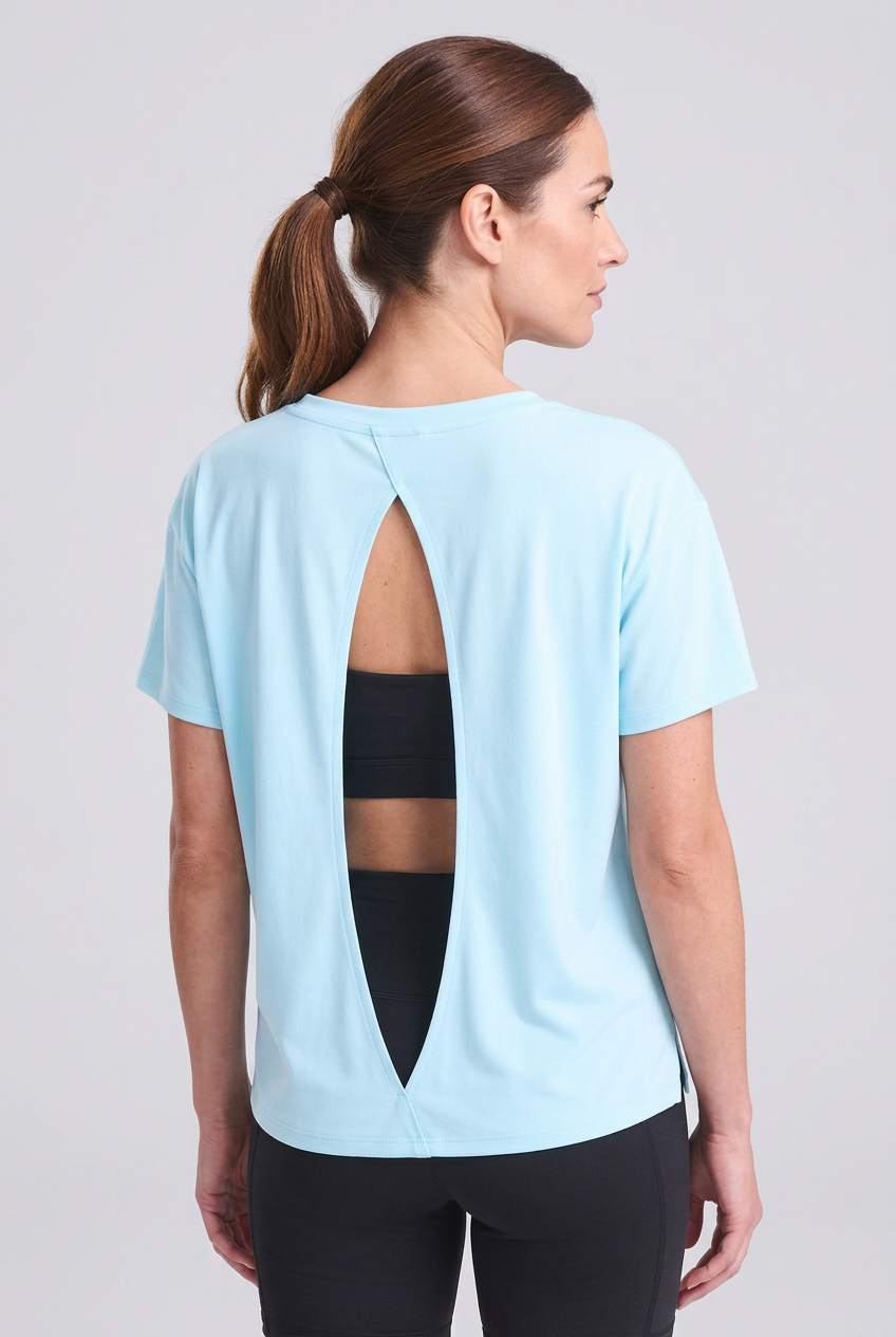 T-shirt sportiva donna azzurra con apertura sulla schiena, indossata